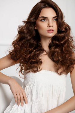 Dalgalı kıvırcık saç modeli ile güzel kız modeli. Kahverengi saç rengi