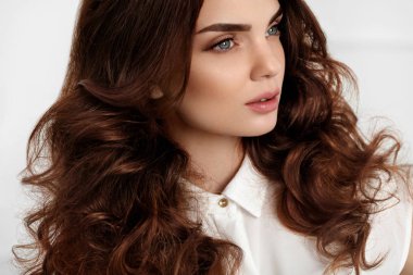 Dalgalı kıvırcık saç modeli ile güzel kız modeli. Kahverengi saç rengi