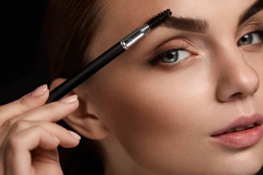 Beautiful Woman Brushing Eyebrows With Brush. Beauty  clipart