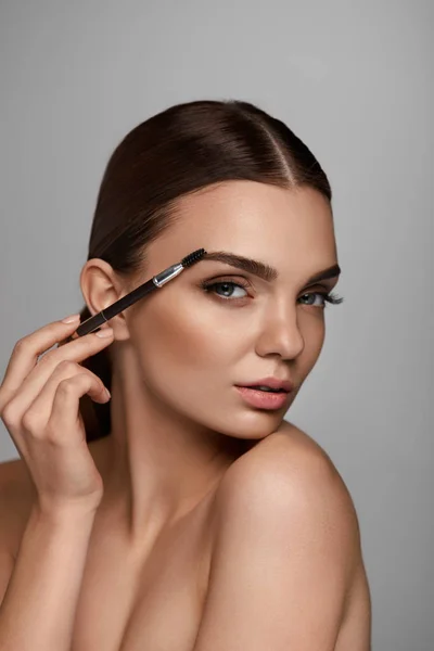 Vacker kvinna borsta ögonbrynen med Brow verktyg — Stockfoto