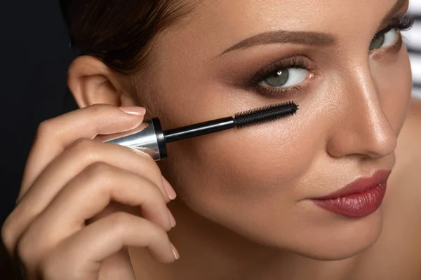 Maquillaje de mujer belleza. Hermosa mujer aplicando rímel negro — Foto de Stock