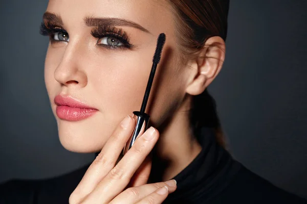 Schönheitskosmetik. Frau setzt schwarze Mascara auf lange Wimpern — Stockfoto