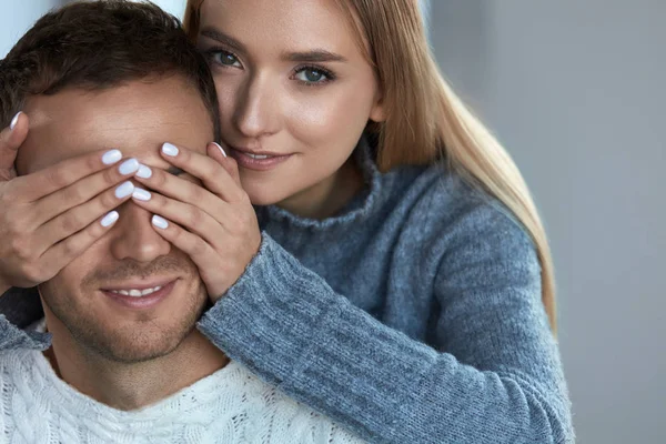 Amour de couple. Belle femme heureuse fermant les yeux de l'homme avec les mains — Photo