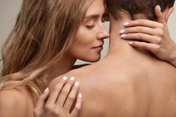 Vacker ung kvinna luktar Man len hud. Par i kärlek — Stockfoto