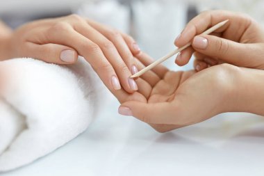 Salon çivi. Ahşap sopa ile eller closeup. Manikür