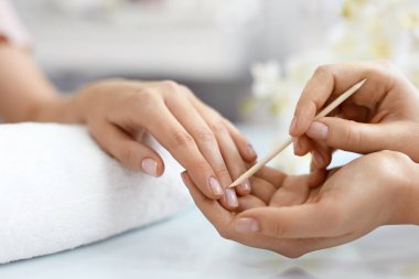 Salon çivi. Ahşap sopa ile eller closeup. Manikür