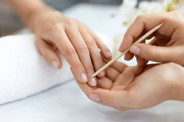 Salon çivi. Ahşap sopa ile eller closeup. Manikür