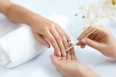 Salon çivi. Ahşap sopa ile eller closeup. Manikür