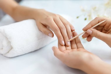 Salon çivi. Ahşap sopa ile eller closeup. Manikür