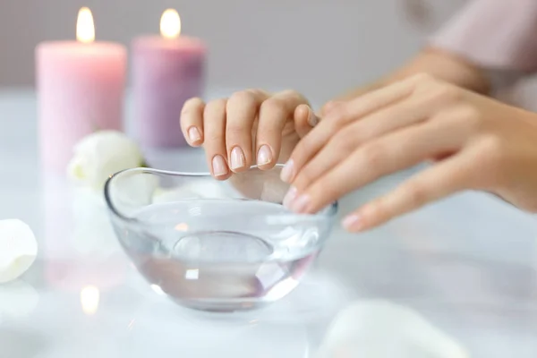 Mulher ensopando unhas naturais na tigela cheia de água. Cuidados com unhas — Fotografia de Stock