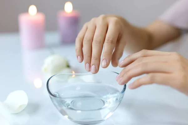 Kobieta napawania naturalnych paznokci w miskę z wodą. Pielęgnacja paznokci — Zdjęcie stockowe