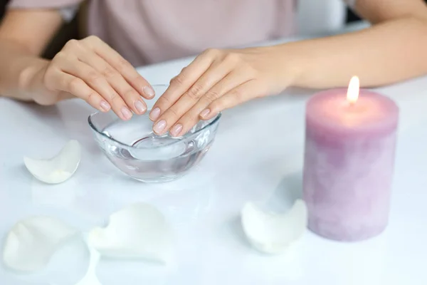 Manicura. Manos femeninas con uñas perfectas empapadas en agua — Foto de Stock