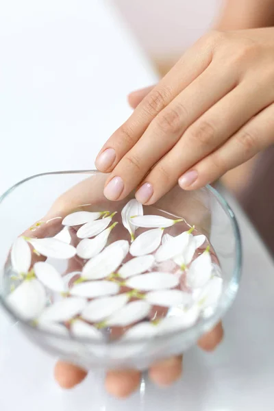 Manicure Spa. Dedos de mulher em banho de aroma com pétalas de flor — Fotografia de Stock