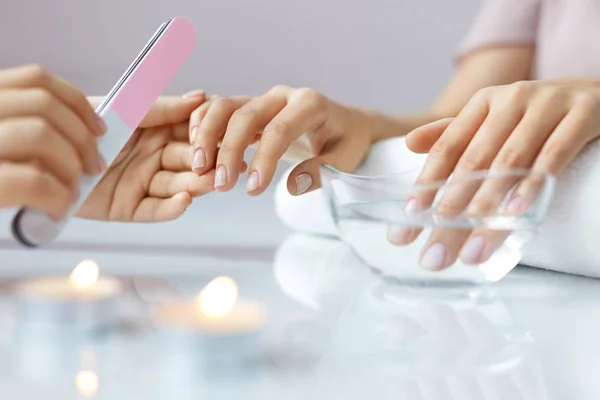 Primer plano hermosas manos femeninas tener manicura de spa, limar uñas — Foto de Stock