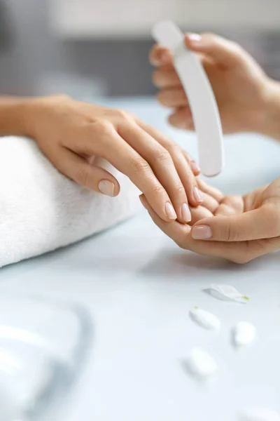 Closeup belas mãos femininas arquivando unhas com arquivo. Manicure — Fotografia de Stock