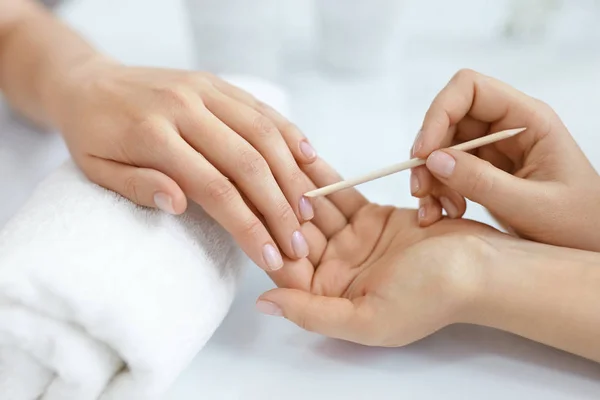 Salon paznokci. Zbliżenie z kobiecych rąk z drewniany kij. Manicure — Zdjęcie stockowe