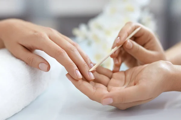 Salón de Uñas. Primer plano de las manos femeninas con palo de madera. Manicura — Foto de Stock