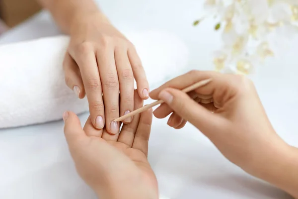 Salón de Uñas. Primer plano de las manos femeninas con palo de madera. Manicura —  Fotos de Stock