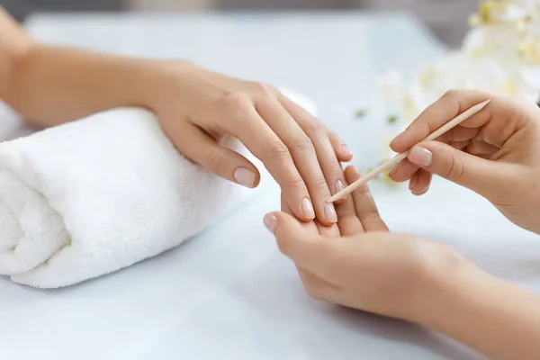 Primeros planos de las manos empujando la cutícula en las uñas femeninas con palo de madera — Foto de Stock