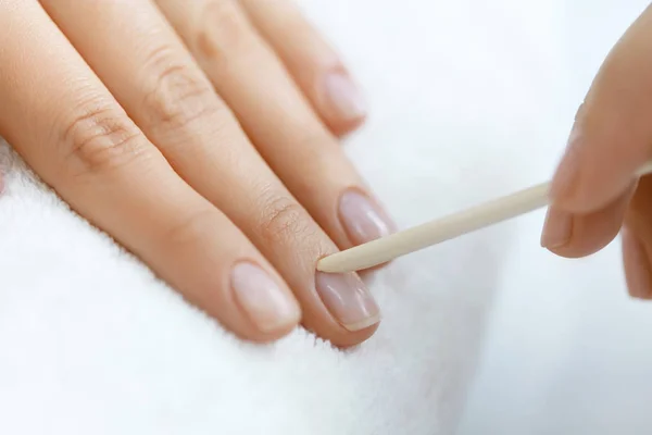 Beautician Removing Cuticle On Woman Hands With Wooden Stick