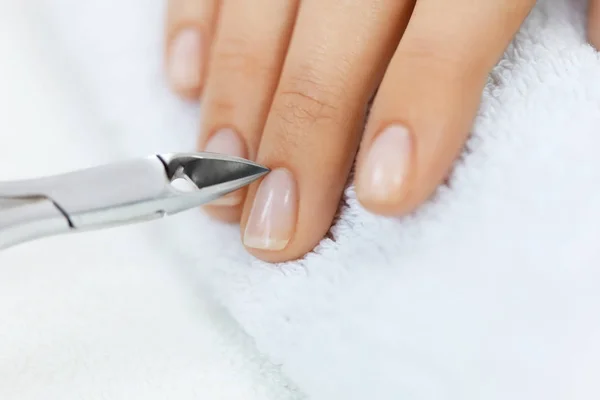 Salón de Uñas. Mano femenina con uñas sanas consiguiendo manicura —  Fotos de Stock