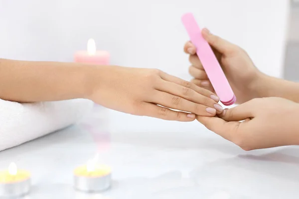 Manicura. Las manos femeninas puliendo uñas con lima de uñas en el salón — Foto de Stock