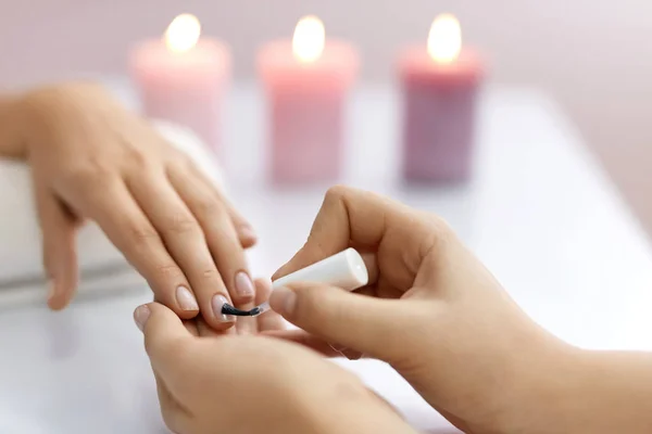 Cuidado de las uñas. Hermosas manos femeninas aplicando polaco en las uñas — Foto de Stock