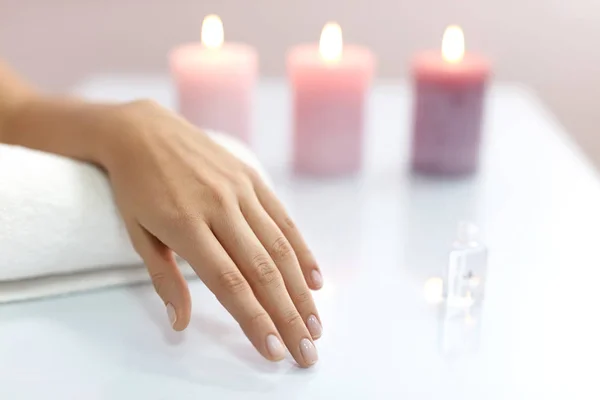 Mujer muestra la mano con uñas naturales saludables en una toalla blanca — Foto de Stock