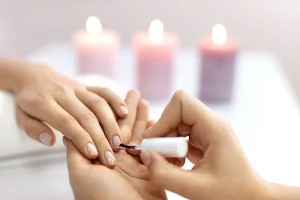 Cuidado de las uñas. Hermosas manos femeninas aplicando polaco en las uñas — Foto de Stock