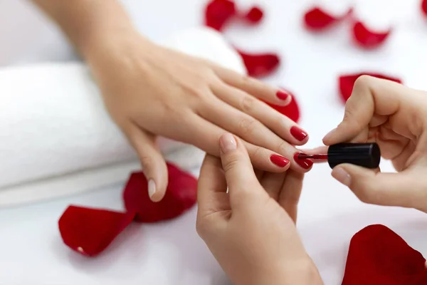 Manicure. Vrouw handen polijsten nagels met rode nagellak — Stockfoto