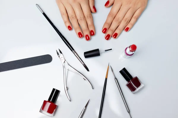 Mãos no ar. Mãos femininas bonitas com polonês vermelho e ferramentas — Fotografia de Stock