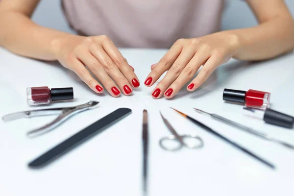Nail Care. Woman Hands With Red Nail Polish And Manicure Tools