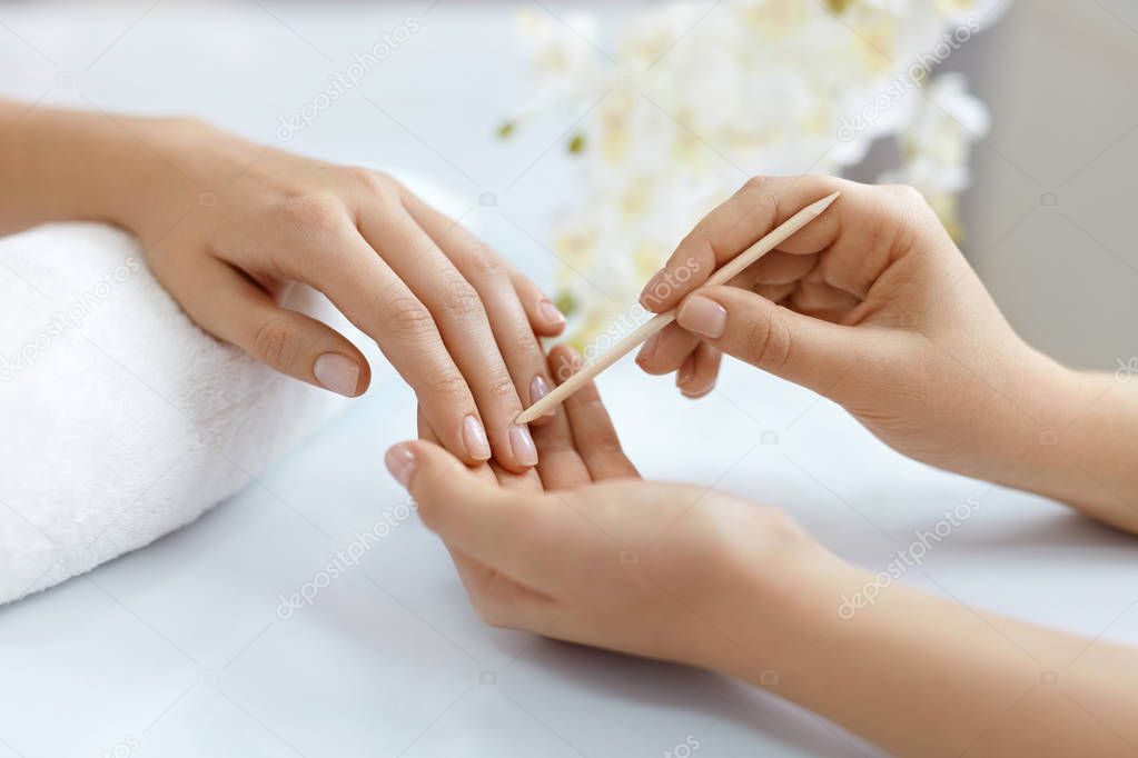 Close-up Hands Pushing Cuticle On Female Nails With Wooden Stick