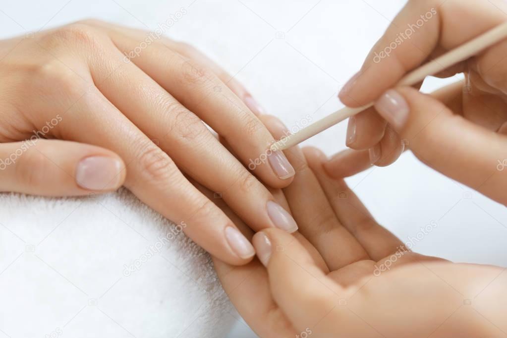 Beautician Removing Cuticle On Woman Hands With Wooden Stick
