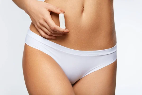 Período das mulheres. closeup mulher magro corpo no biquíni segurando Tampon — Fotografia de Stock