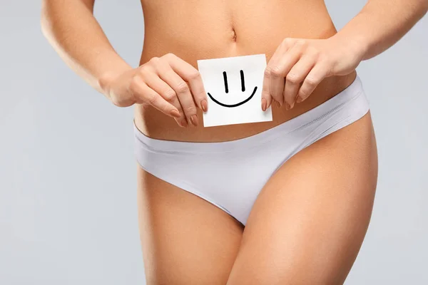 Salud de las mujeres. Hermoso cuerpo femenino en bragas con tarjeta sonriente — Foto de Stock