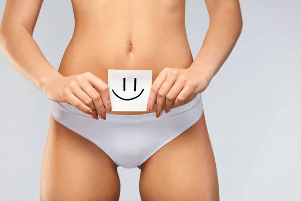 Salud de las mujeres. Hermoso cuerpo femenino en bragas con tarjeta sonriente — Foto de Stock