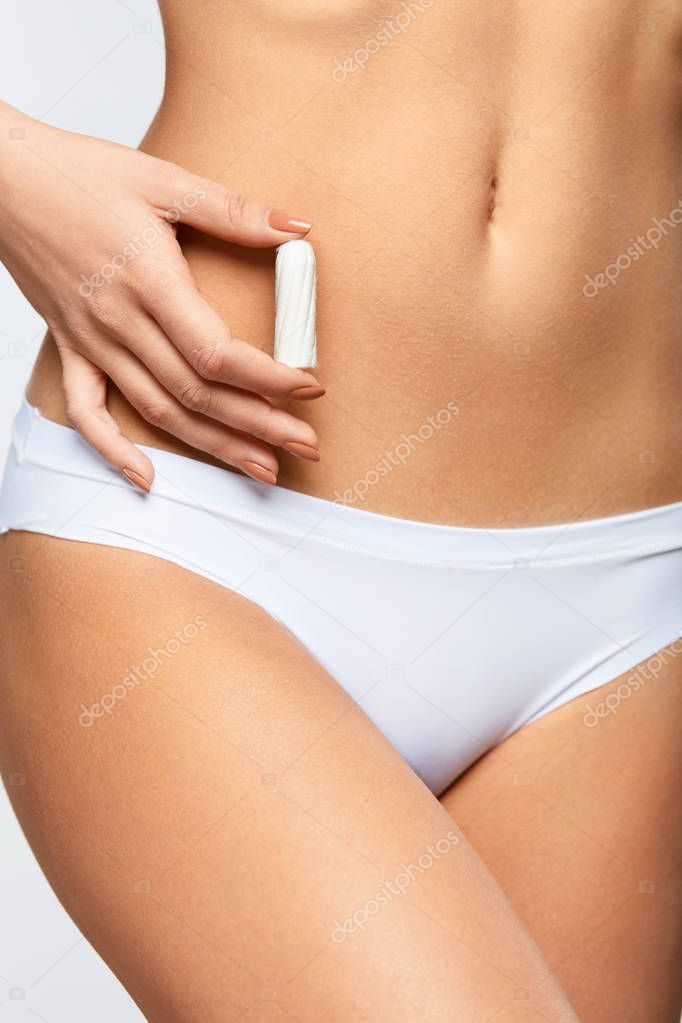  Women Period.  closeup Woman Slim Body In Bikini Holding Tampon