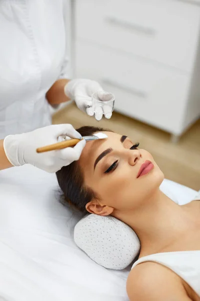 Kosmetikerin im Wellness-Salon hydratisiert das schöne Frauengesicht — Stockfoto