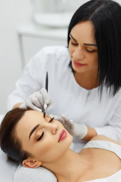 Beautician Doing Eyebrow Makeup Tattoo On Woman Using Machine — Stock Photo, Image