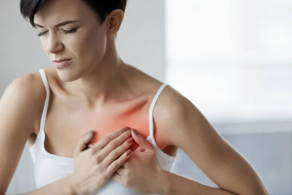 Серцева атака. Красива жінка відчуває біль в грудях. охорони здоров'я — стокове фото
