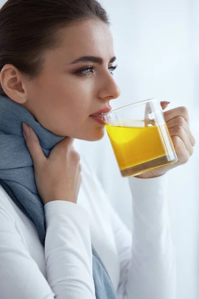 Wanita sakit yang cantik minum minuman kuning, obat dari dingin — Stok Foto