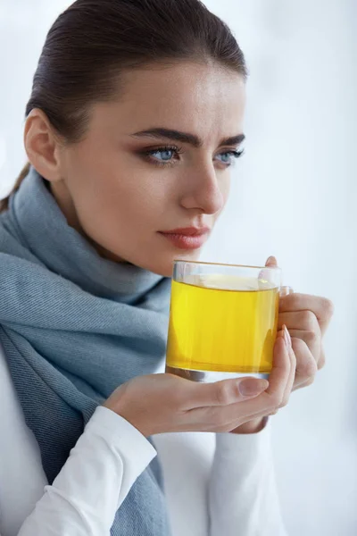 Krásná žena s horkým nápojem, pití, oteplování žlutý nápoj — Stock fotografie