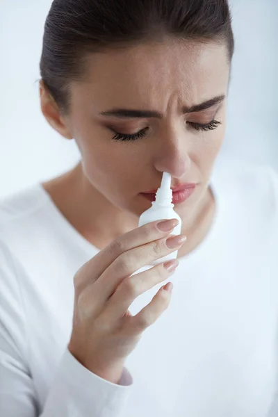 Frío. Hermosa mujer usando aerosol nasal — Foto de Stock