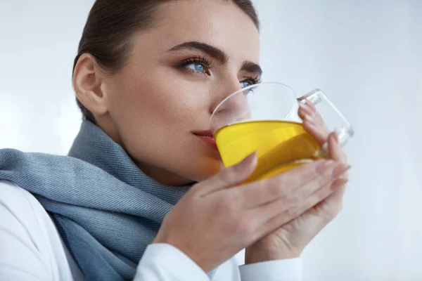 Mooie zieke vrouw gele drinken drinken, geneeskunde van koude — Stockfoto