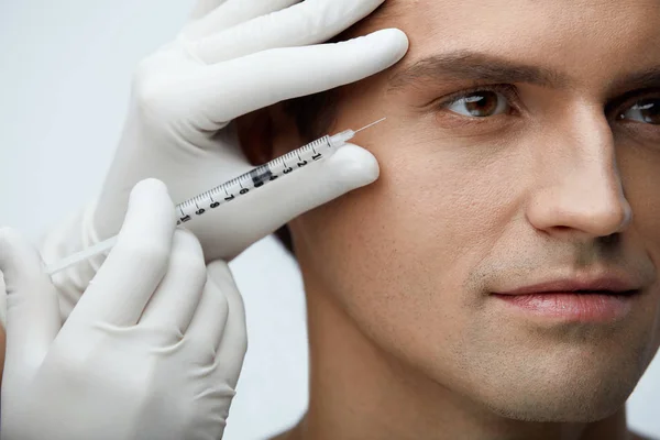 Hombre guapo recibiendo tratamiento de belleza facial, inyecciones de relleno —  Fotos de Stock