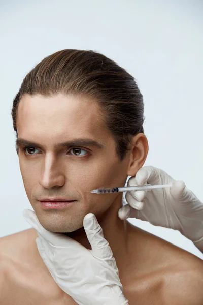 Kosmetička dělá kosmetická injekce v mužských pacientů obličej — Stock fotografie