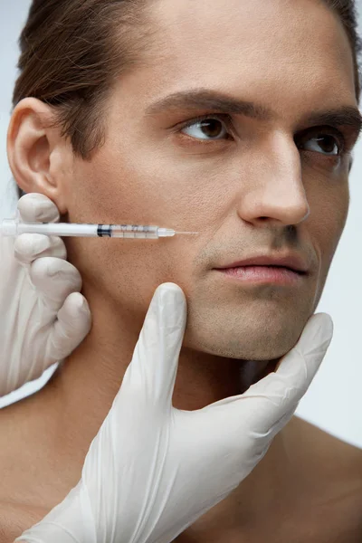 Inyección de belleza masculina. Hombre guapo recibiendo inyecciones faciales — Foto de Stock