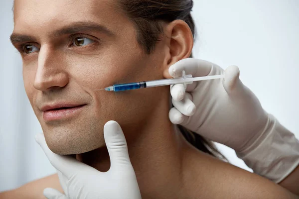 Iniezione di bellezza. Bello uomo getting faccia filler iniezioni — Foto Stock