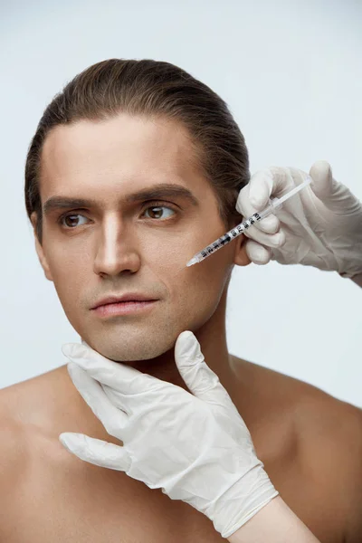 Esteticista fazendo injeção cosmética no rosto masculino do paciente — Fotografia de Stock